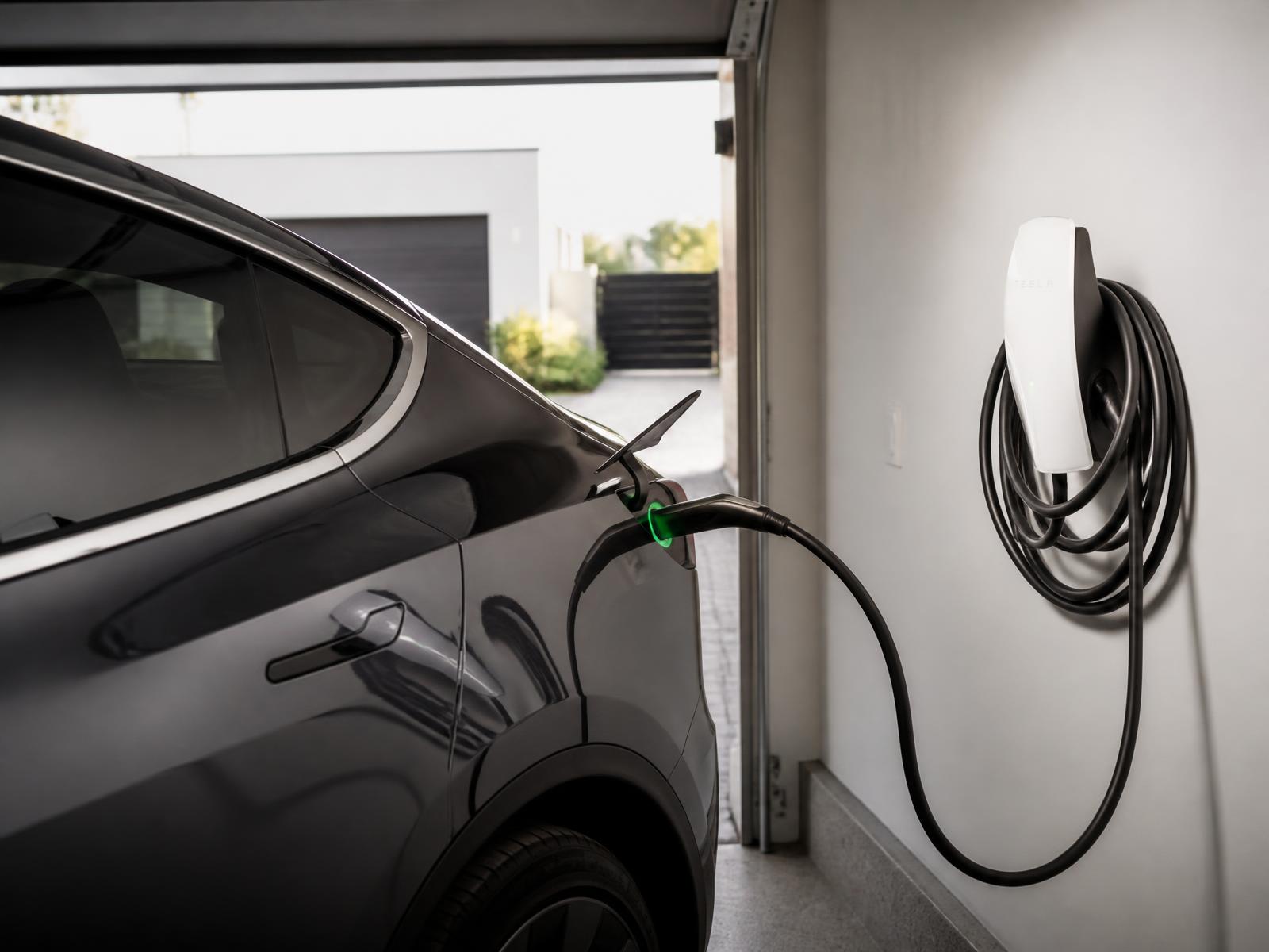 Tesla Wall Connector charging a Tesla in a home garage